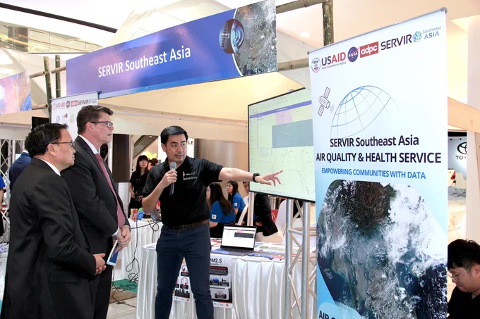 Aekkapol Aekakkararungroj, SERVIR SEA Geospatial Data Scientist demonstrates features of Air Quality Tracker to Michael McCord, Country Representative, USAID/Laos, and Lienxay Bounmanivanh, Director-General, NRERI, Laos MONRE.