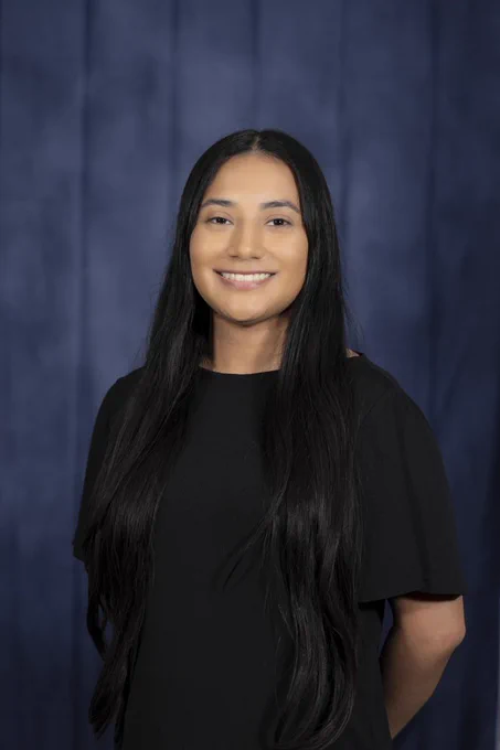 blue photo background. smiling professional headshot female. 