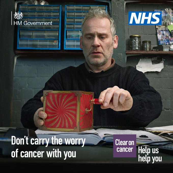 ‘A middle-aged person sitting with a red jack-in-the-box toy on the table across from them. The person is turning the handle of the red-jack-in-the-box and has a concerned expression on their face. The text reads: ‘Don’t carry the worry of cancer with you’. The NHS logo is in the top right hand corner.’