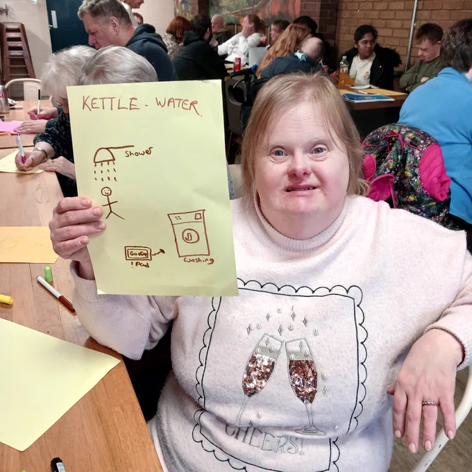 Showing her 4 best ways to save energy, less water in the kettle,  shorter  shower,  unplug charger and fill the washing machine
