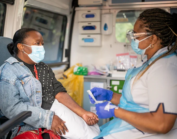 A nurse and patient about to begin tests inside a mobile cancer unit.