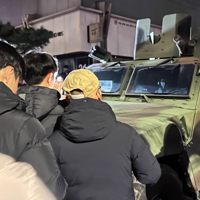 A photo of a tank near South Korean citizens
