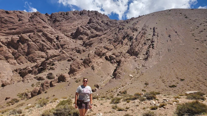 Image Credit: PhD student Chloë Weeks in front of growth strata in the Manantiales Basin of the Frontal Cordillera, Argentina.
