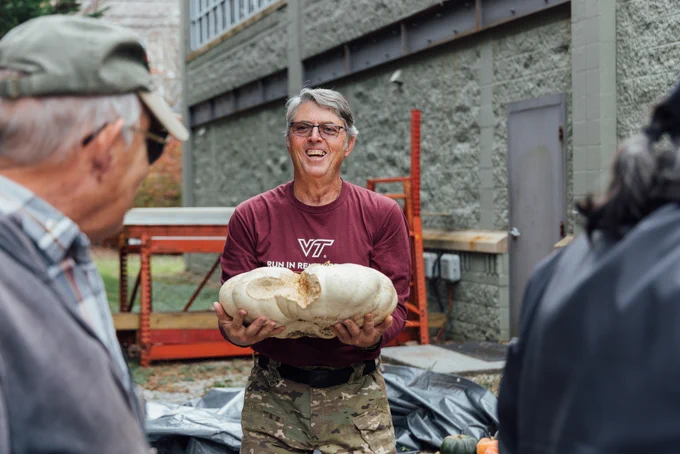 John Galbraith holds a large pumpkin