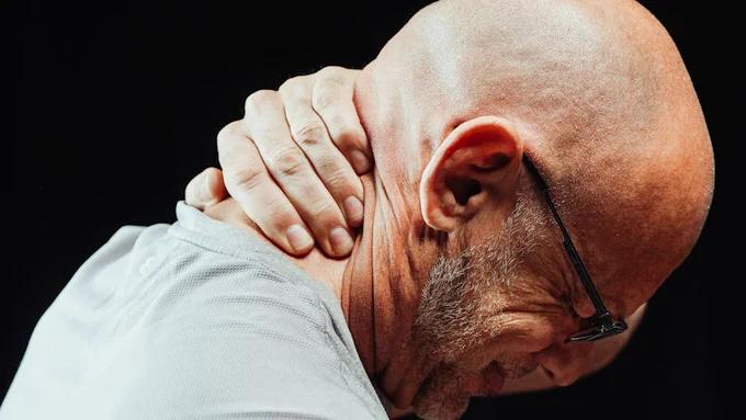 Side view of senior man holding neck with visible discomfort, highlighting neck pain relief.