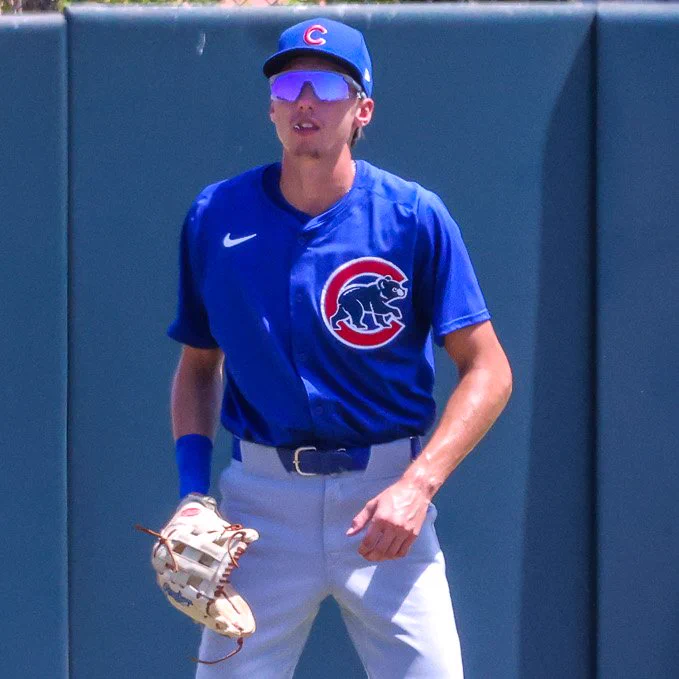 Eli Lovich wears a blue Cubs uniform top with a blue cap and blue-tinted sunglasses.