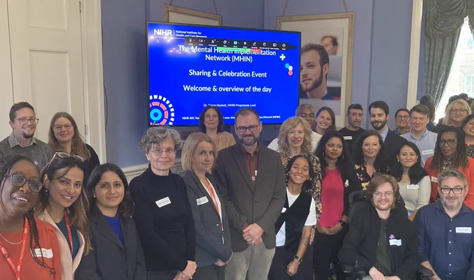 Group of diverse people standing in front of a presentation screen