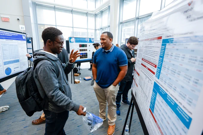 Students discussing research posters.