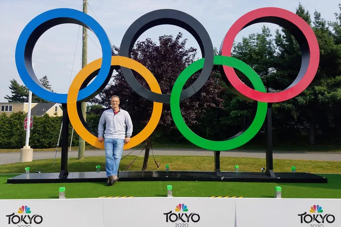 Bill smiles for a photo with the Olympic ring sculpture at the Tokyo Olympics