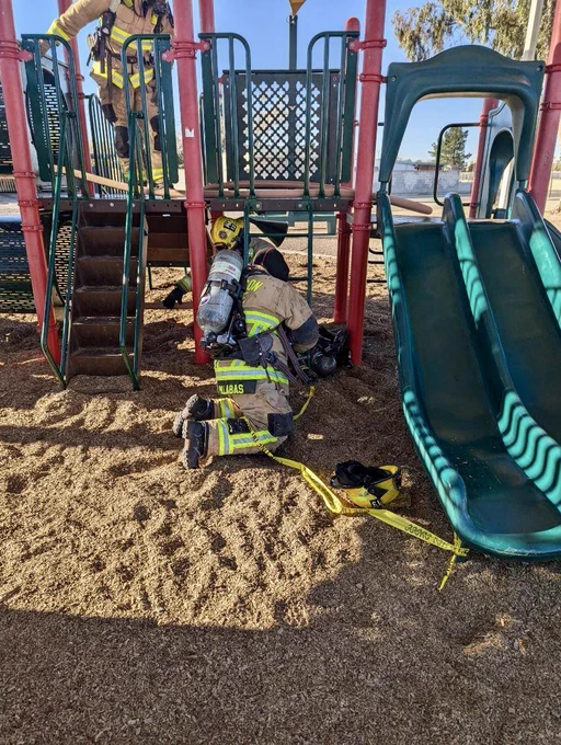 Firefighters use playground to practice hose management around obstacles