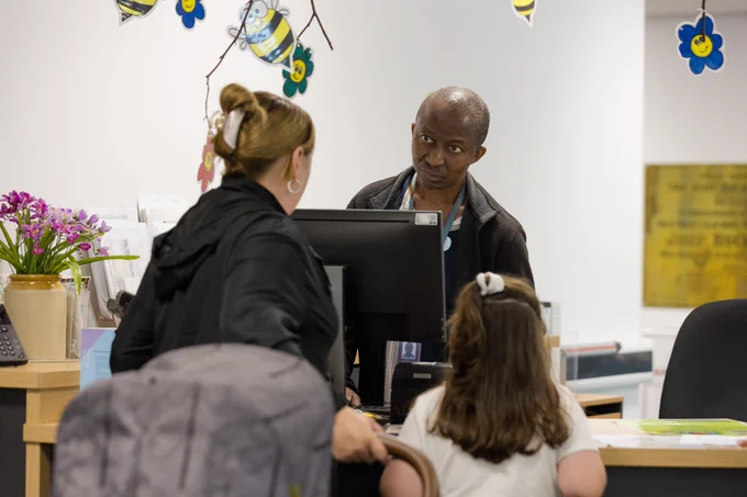 A woman and child are advised by a male librarian.