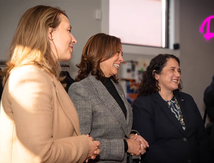 Kamala Harris and two other individuals smiling during an indoor event.