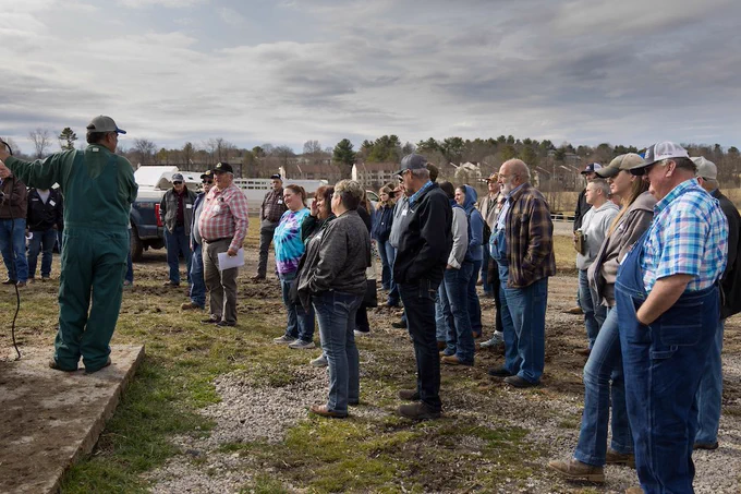 A group of conference attendees listens to a speaker