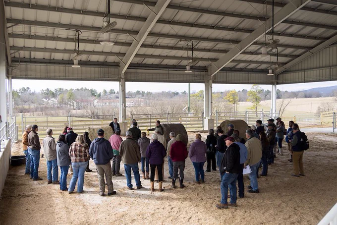 A group of attendees gathers to hear from a speaker