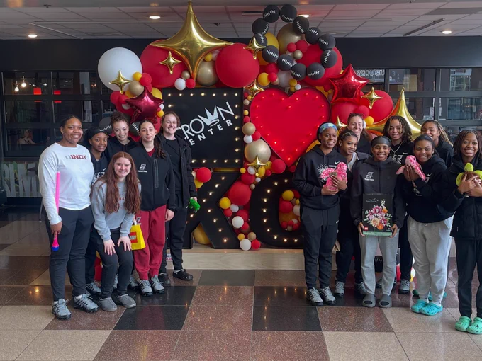 The team shows off with smile in front of a welcome sign at Crown Center.