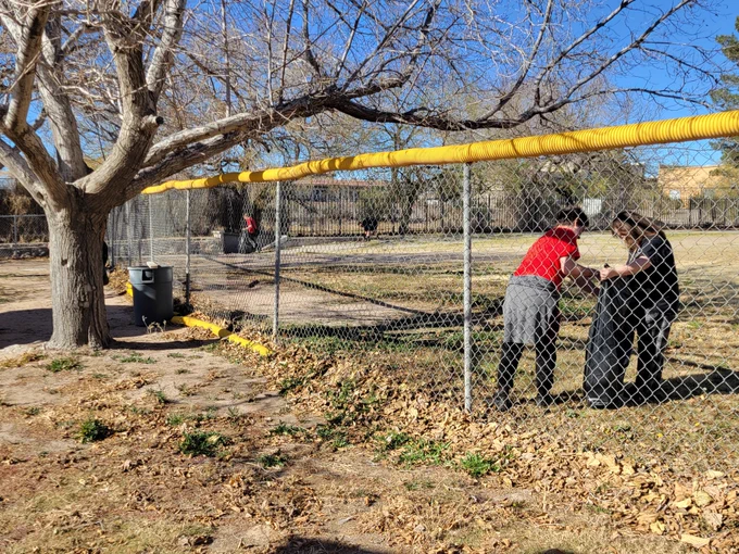  Two students pick up trash during a community cleanup project.