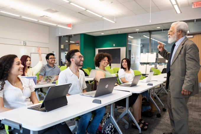 George Mason University students seated in a classroom while their professor lectures.