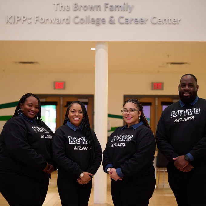 Atua Emu, Melanie Harper, Jodeci Acosta-Gorman, and Irving Williams appear wearing matching “KFWD Atlanta” black sweatshirts. They are all standing in the Brown Family KIPP Forward College & Career Center on campus at KIPP Atlanta Collegiate High School. They are members of the KIPP Forward Team which received the 2025 Excellence in College Counseling award. 