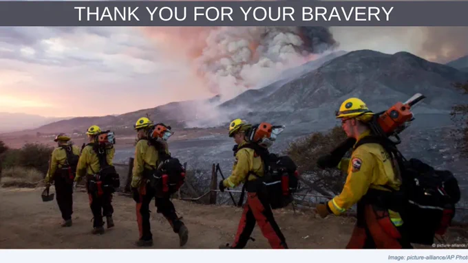 firefighters walking to a smoldering mountain