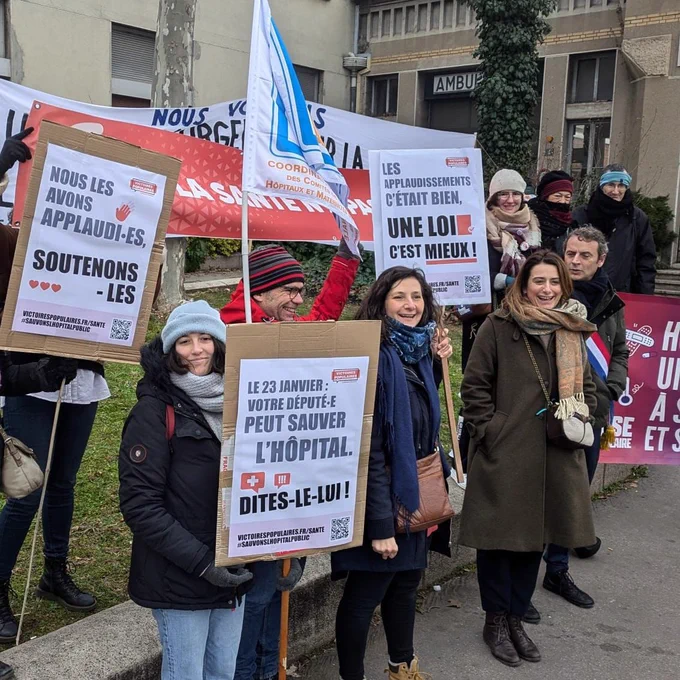 De nombreuses personnes avec des pancartes devant un hôpital 