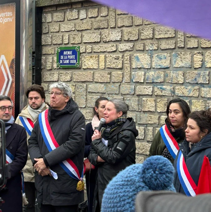 Lucie Castets avec un micro à la main à côté d'autres personnes avec des écharpes d'élus