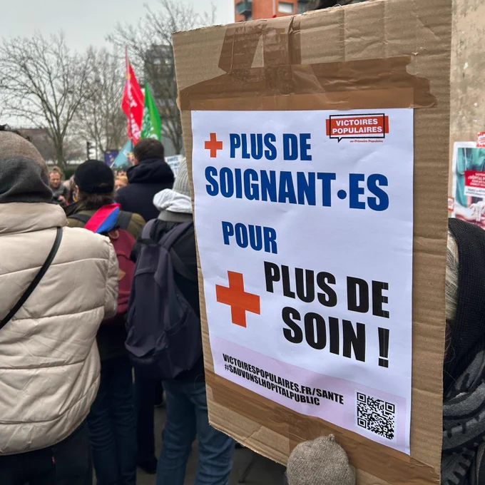 Une manifestation avec une pancarte où est écrit : plus de soignant.es pour plus de soin !