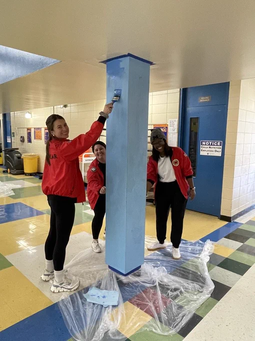 a volunteer painting a column