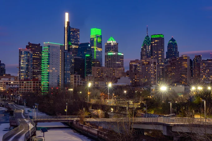 Philadelphia skyline lit up with green lights.