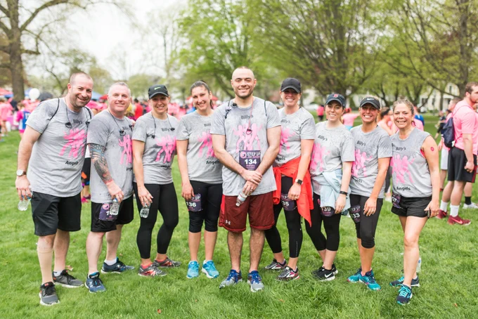Group of people standing on grass smiling at the camera wearing gray shirts that say Billy's Angels.