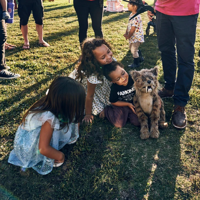 Children clamor over Nibbles the Saber-toothed kitten puppet at La Brea Tar Pits & Museum.