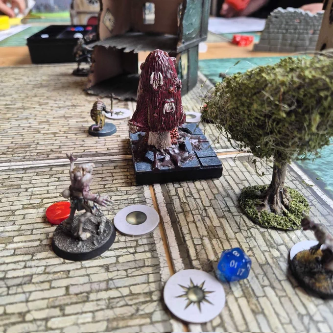 A game of Forbidden Psalm being played in Ancient Robot Games. Miniatures and terrain on a table.