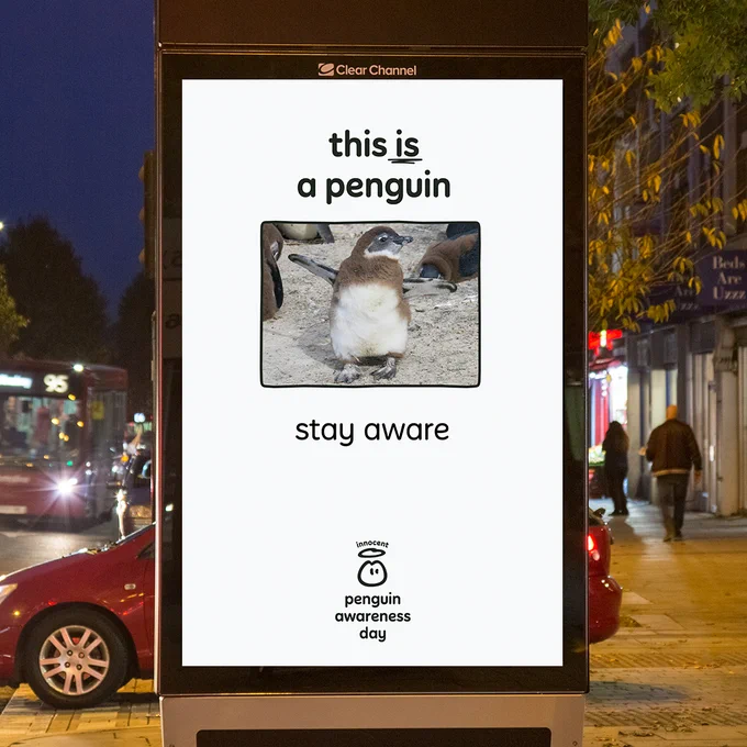 In this picture, we have one of those digital screens outside. But this isn't a regular advert. It's a penguin awareness advert. On the screen, there's text on top which says 'this is a penguin'. Underneath there's a picture of a cute furry baby penguin that looks about as dangerous as a bubble. We've put 'stay aware' underneath it. 