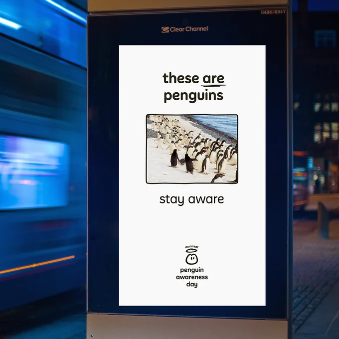 In this photo, on another screen we now have a picture of a herd of penguins. Below, we've put text... Yep, you guessed it. 'These are penguins. Stay aware.