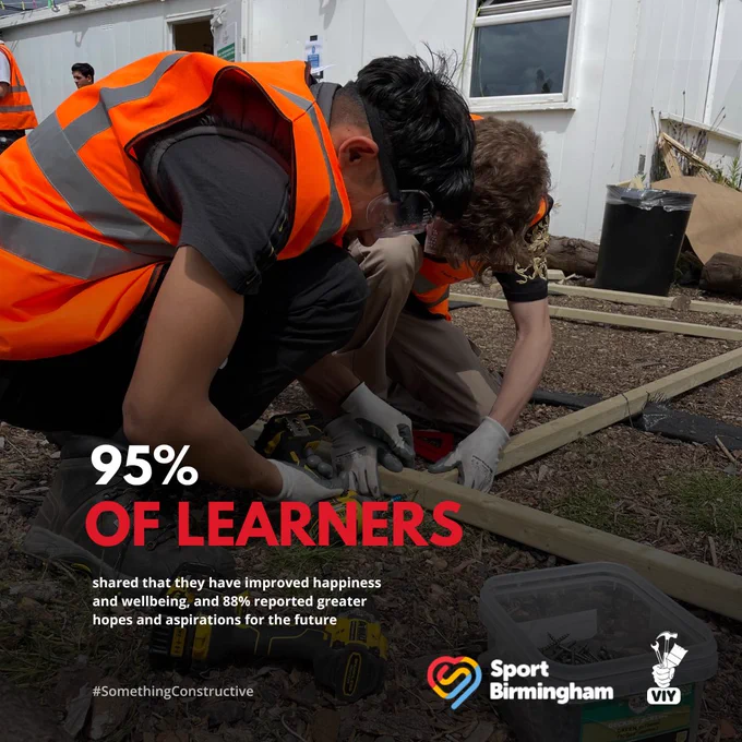 Two volunteers wearing high-visibility vests work together to measure and cut wood outdoors, with a toolbox nearby. The image includes statistics about learner satisfaction and is associated with Sport Birmingham and VIY (Volunteer It Yourself).