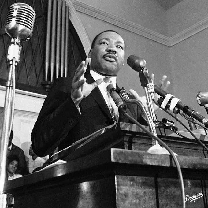A photo of Dr. Martin Luther King Jr speaking at the podium.