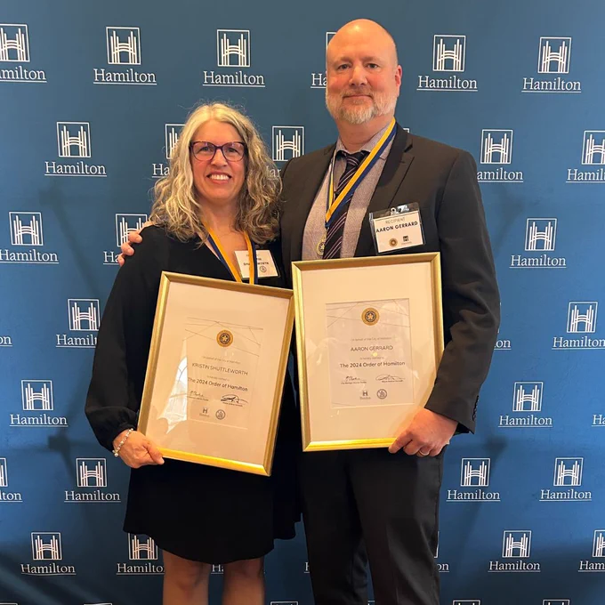 Photo of Kristin and Aaron holding their 2024 Order of Hamilton framed certificates.