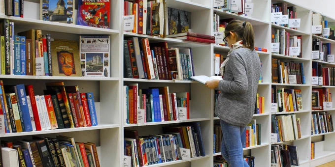 image of a woman browsing a bookshelf