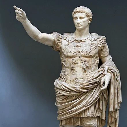 Roman statue of Augustus, his right arm is raised, elbow bent, and his hand only slightly open which his index finger slightly protruding.