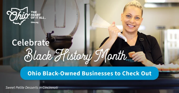 Banner image promoting Black History Month, featuring the logo 'Ohio, The Heart of It All', and a chef from Sweet Petite Desserts in Cincinnati smiling while holding a dessert. Text encourages visiting Ohio Black-Owned Businesses.