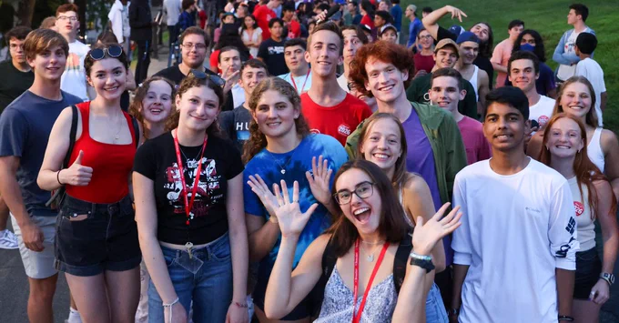 Group of enthusiastic students gathered outdoors at RPI's orientation program, smiling and posing for the camera.