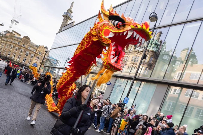 People carrying the dragon on poles down Blackett Street