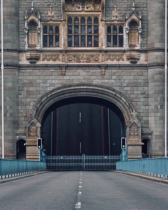 Tower Bridge's raised street level photographed through the Tower's arches.