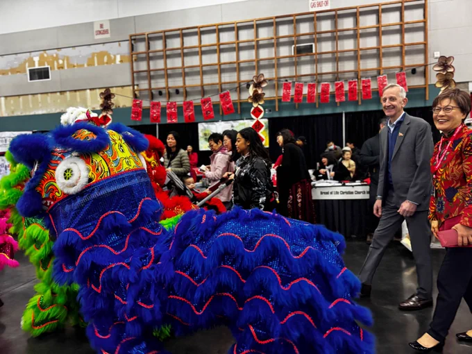 Image of Mayor Wilson walking next a dragon costume during a Chinese New Year's celebration at the Oregon Convention Center