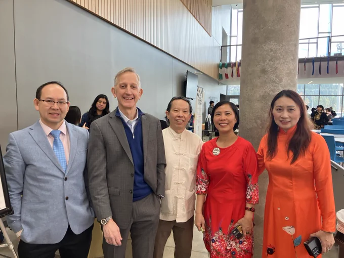 Image of Mayor Wilson taking a group photo with four people at the Vietnamese Community of Oregon celebration at McDaniel High School