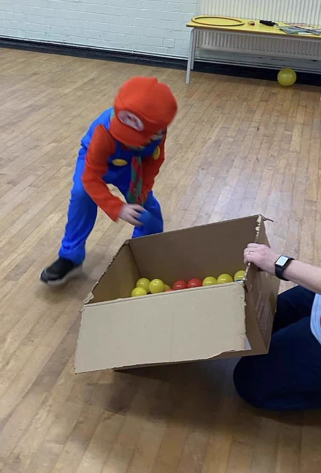 Squirrel Scout dressed as Super Mario plays game with balls