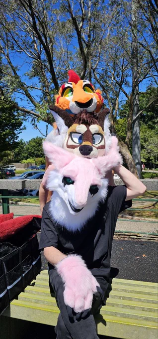 3 fursuiters posing for a photo with their heads ontop of each other