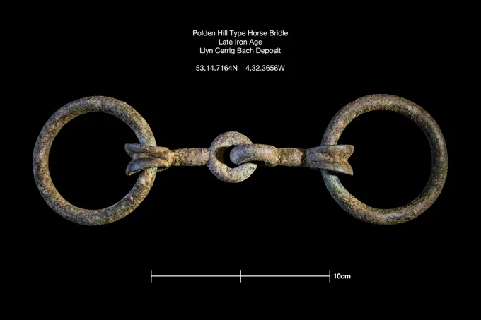 A metal horse bridle-bit, made of two metal rings, joined together by another piece of metal. 