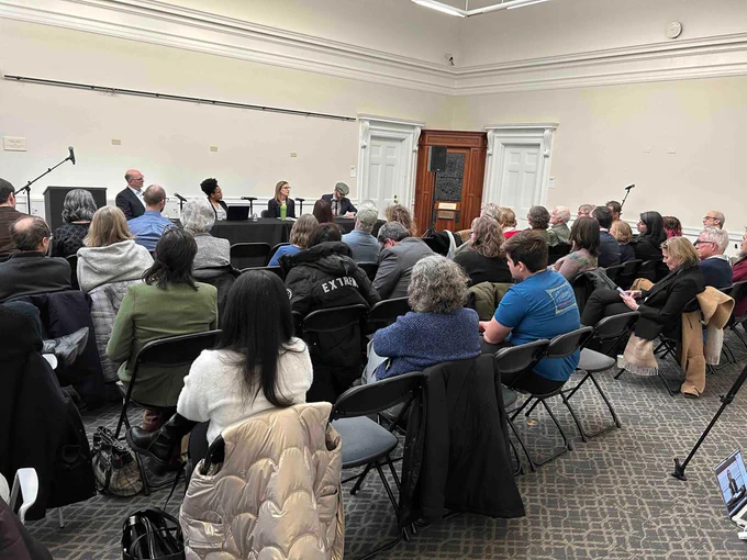 wide shot of the attendees and the panelists at the head of the room