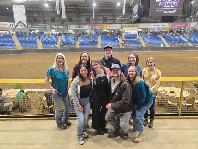 A group of people posing for a photo in an arena setting
