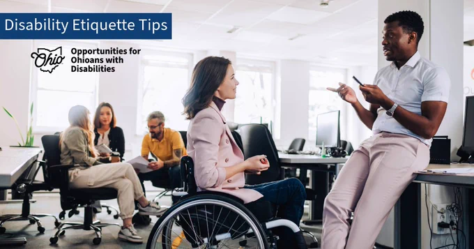 Two professionals having a conversation at work. One uses a wheelchair. Three other individuals converse in the background. Text, "Disability Etiquette Tips." OOD logo.